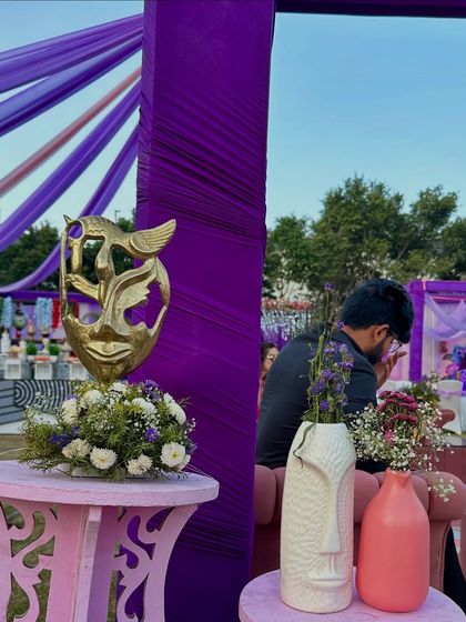 We love adding unique decor pieces like these artistic masks and face vases to complement the purple and pink theme of this Haldi carnival.