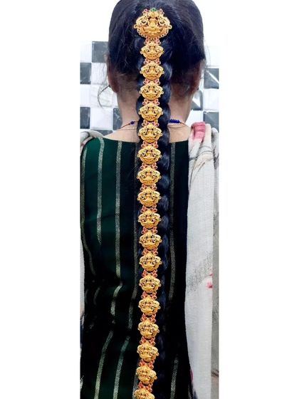 A traditional South Indian 'Jadai Billai' hair ornament, designed to decorate a long braid. This piece is crafted with temple-style motifs.