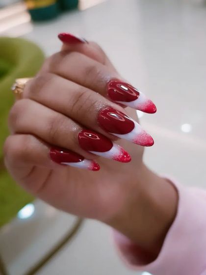A close-up of the red and white abstract nail art.