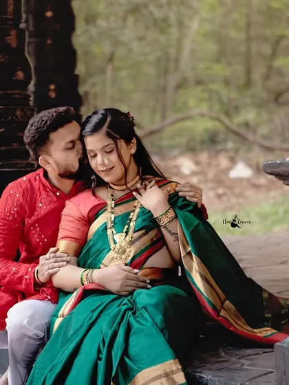 Blending tradition with tenderness, this portrait from a cultural maternity shoot shows the couple in a quiet, loving embrace. The rich green saree and red kurta create a beautiful contrast against the traditional architecture.