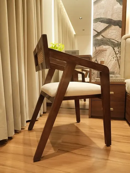 The beauty of simplicity is captured in this wooden chair with rattan detailing. It's the perfect accent piece for a cozy reading corner in a bedroom, inviting you to sit back and relax.