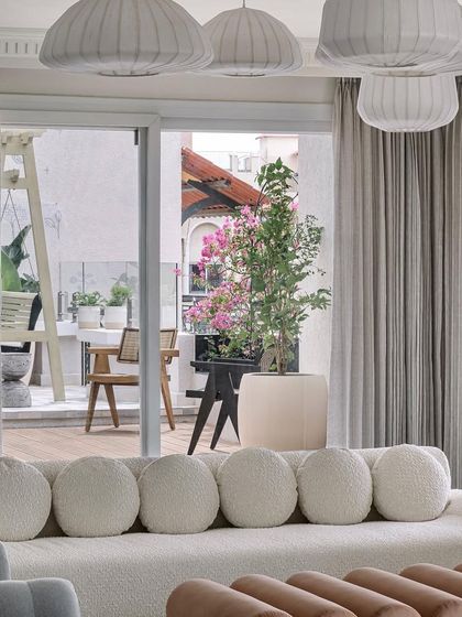 A view from the living room out to the terrace balcony, where a bougainvillea-lined arch frames a charming seating nook.