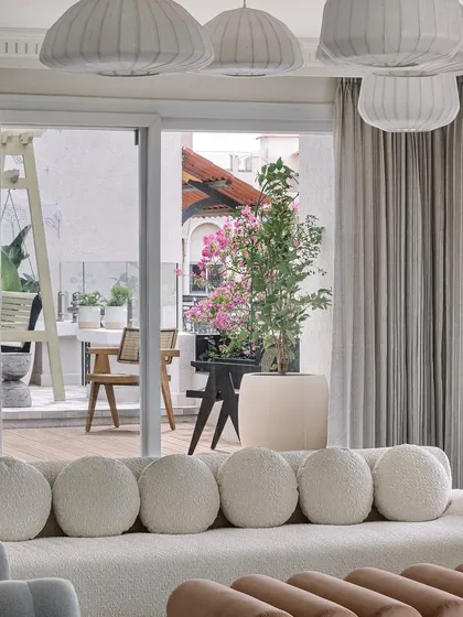 The formal living area opens up to an outdoor deck, complete with a swing and lush plantings. The hand-painted mural on the wall adds a nostalgic, charming touch.