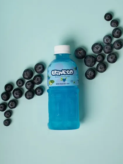 A top-down shot of a blueberry drink with fresh blueberries scattered like a swirl. This artistic flat lay is visually engaging and perfect for social media.