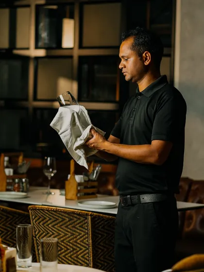 My dedicated staff preparing every detail to ensure a memorable experience at Camillo's. Here, a team member polishes glasses to perfection.
