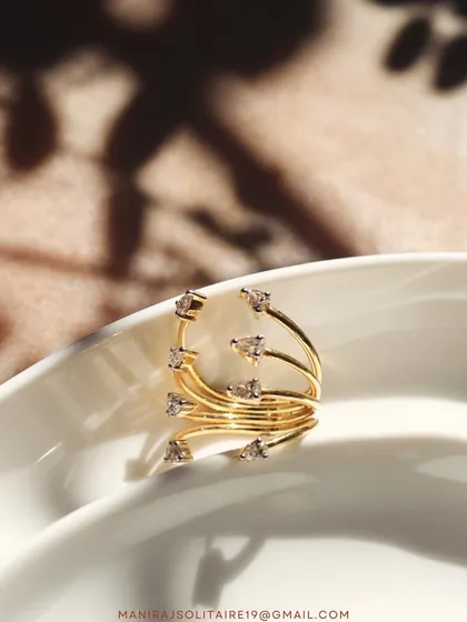 A delicate and whimsical design. This swirling multi-band ring is dotted with diamonds, creating the look of sparkling dewdrops on a vine.