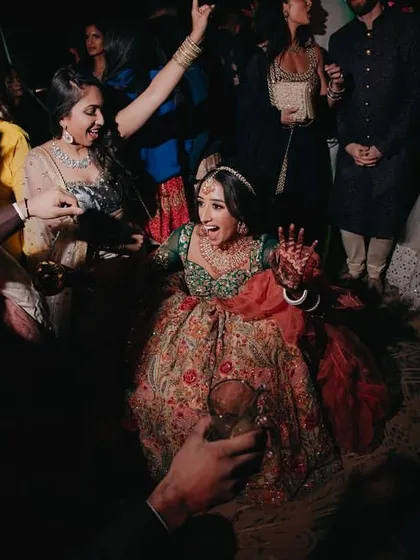 The bride enjoying a dance performance during the Sangeet, her joy lighting up the evening.