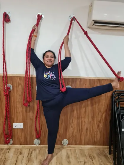 This student finds confidence in her standing split with the help of the wall ropes. This is a great example of how we build strength and flexibility progressively.