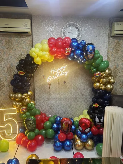 Superhero parties are one of our most requested kids' themes. For this 5th birthday, we assembled the Avengers with a full ring balloon arch in character colors, a 'Happy Birthday' neon sign, and a light-up number '5'. We can bring any hero universe to life for your little one.