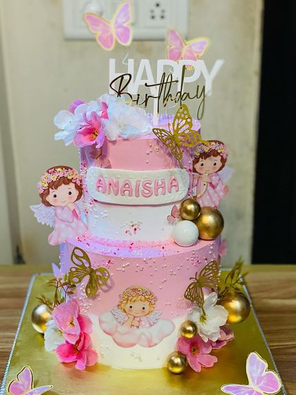 A beautiful two-tier angel and butterfly themed cake, perfect for a little girl's birthday.