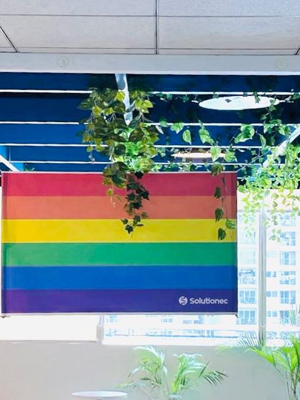 The Pride flag displayed in our office window. We are committed to visibly showing our support and fostering an inclusive atmosphere.