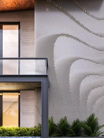 A close-up detail of a perforated metal facade with a flowing, wave-like pattern. This element adds an artistic and textural layer to the building's exterior while providing a degree of transparency.
