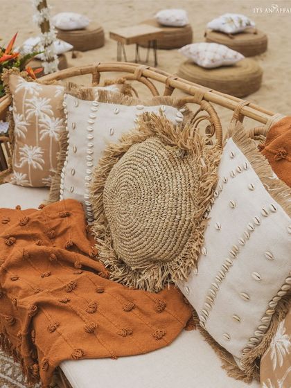 A close-up of the textural details, including cushions made of jute, shells, and palm-print fabric, perfect for the tropical beach theme.