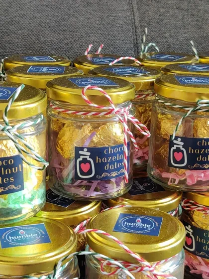 These Choco Hazelnut Dates are one of my most loved items for gifting. Each date is filled with a crunchy hazelnut, coated in chocolate, and wrapped by hand. They look beautiful in these little glass jars and make for a perfect, healthy indulgence for corporate events or festival hampers.