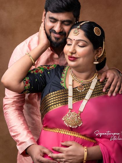 The focus here is on the emotional connection, with the rich colors of the saree adding to the warmth of the image.