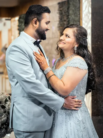 A romantic portrait of a couple at their engagement party, dressed in elegant formal wear.