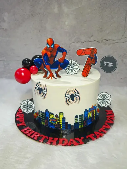 Your friendly neighborhood Spider-Man swings into the party on this custom birthday cake. The design includes an edible city skyline wrap and spiderweb details, perfect for a young superhero fan's 7th birthday.