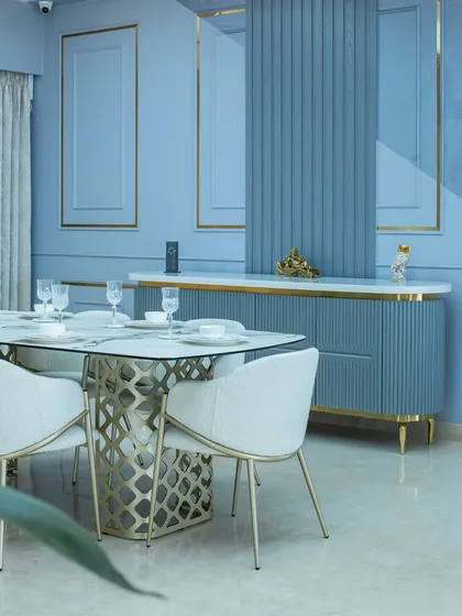 A closer look at the fluted crockery unit and the intricate golden base of the dining table. These details add a layer of luxury and texture to the space.