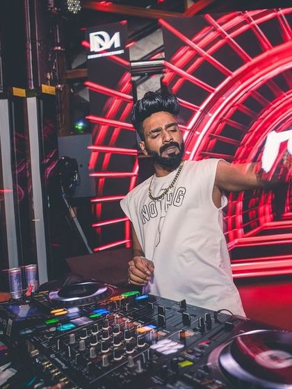 Hands in motion on the mixer at FLO, with the red glow of the club's lighting.