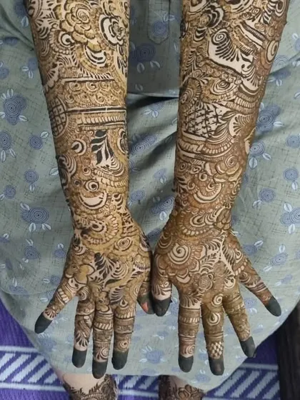 A full view of a bridal client's hands, showcasing the intricate patterns that cover her arms. The design is dense and traditional, exactly what a bride needs for her big day.