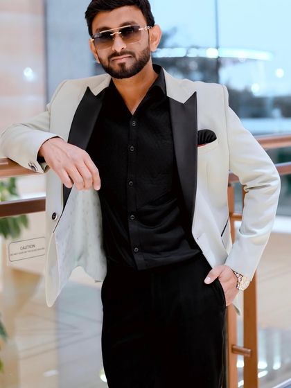 Leaning against a railing, this shot showcases a smart-casual look ideal for business seminars or team outings. The sunglasses add a touch of modern flair.