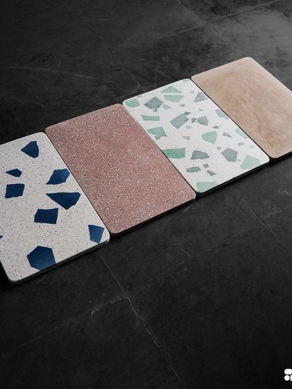 A lineup of four different terrazzo samples, showcasing a range of colors and patterns from bold blue Venetian to earthy pink and green.
