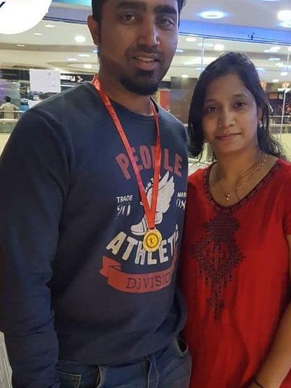 This couple celebrates a successful archery session. The gentleman proudly wears his medal, marking a great day of sport.