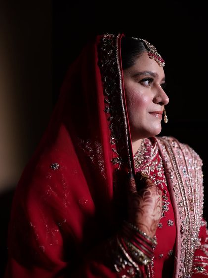 A side profile portrait capturing the bride's elegant features and her traditional nose ring. The makeup is soft yet defined.