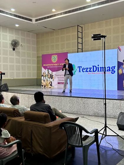 A wide shot of the stage setup for our Kishangarh seminar. You can see the professional setup with multiple screens, banners, and a camera crew, ensuring a high-quality experience for our large audience.