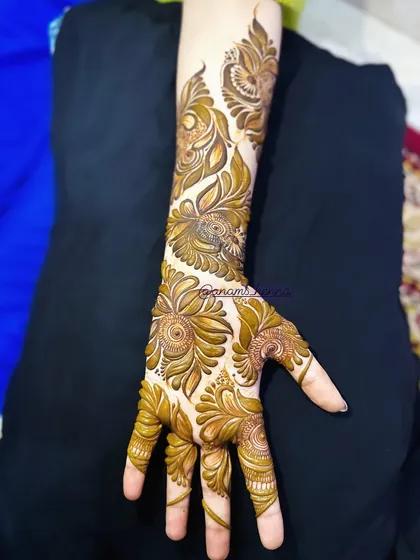 This full-arm design showcases a beautiful blend of Arabic and Indian styles, with bold floral vines running up the arm. The details are fine and precise.