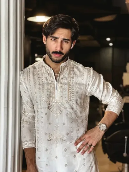 An elegant white kurta with subtle gold embroidery, perfect for a sophisticated daytime event or puja.