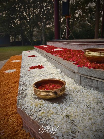A detail of flower petals arranged on steps with traditional brass bowls, adding a touch of color and elegance to the venue's architecture.