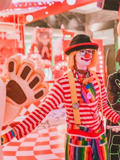 A colorful clown and futuristic LED performers entertain guests at the circus party. I love to mix classic entertainment with modern twists to create a unique and dynamic experience.