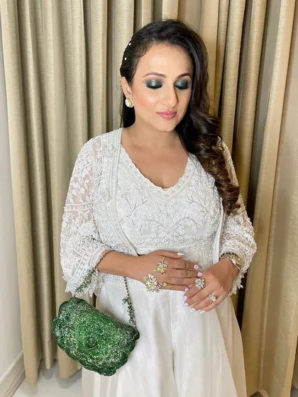 A touch of creative color. I matched her eye makeup to her stunning green bag, creating a cohesive and high-fashion look with a beautiful green smokey eye and a flawless, dewy complexion.