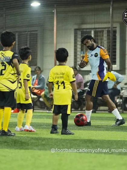 Coaching is about connection. Here, I'm breaking down a drill for my youngest players, making sure they understand the 'why' behind the 'what'. I believe individual attention is key to building a strong foundation.