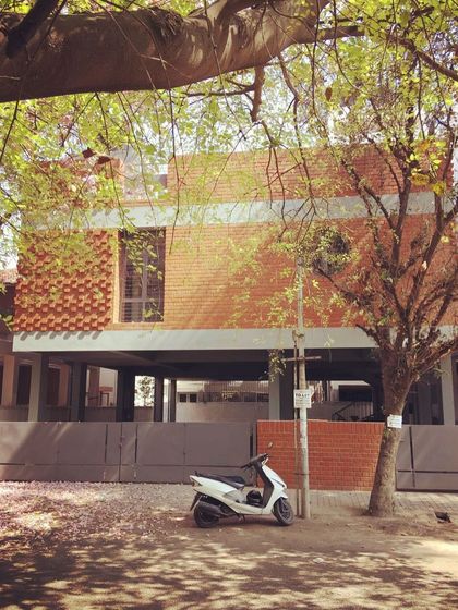 Another perspective of the HSR residence, framed by local greenery. The combination of exposed brick, smooth concrete bands, and the surrounding trees showcases our commitment to creating architecture that feels connected to its place.