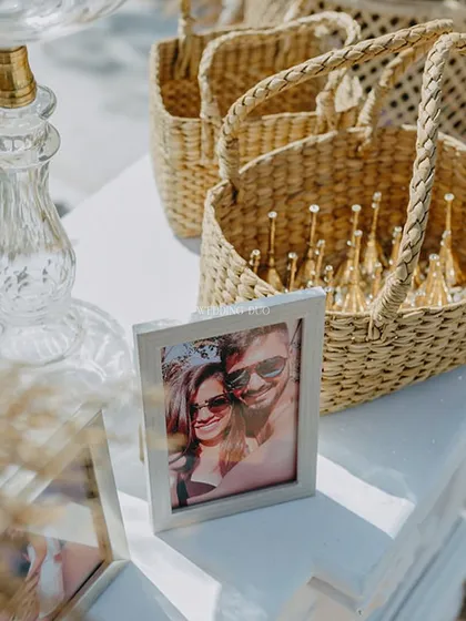 A close-up of the memory table, where a sweet photo of the couple is placed next to woven baskets holding favors for the guests.