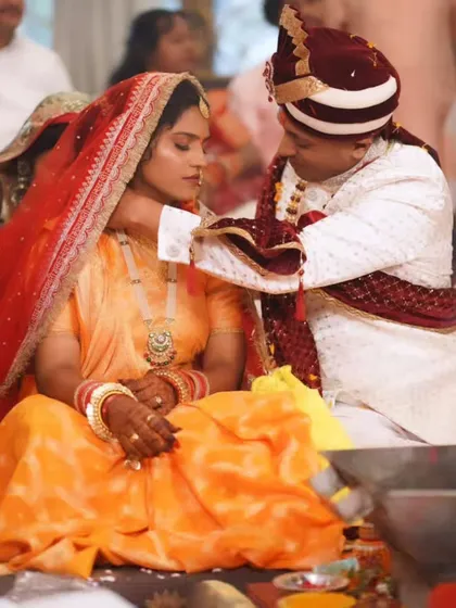 The sacred mangalsutra ritual, a moment of deep significance. The bride's makeup is soft and reverent.