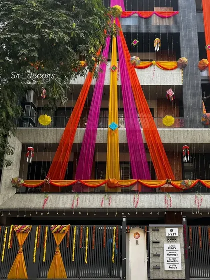 Even during the day, your home will look like a celebration. I use long, flowing drapes in bright colors like pink, yellow, and orange to decorate the entire front of the building.