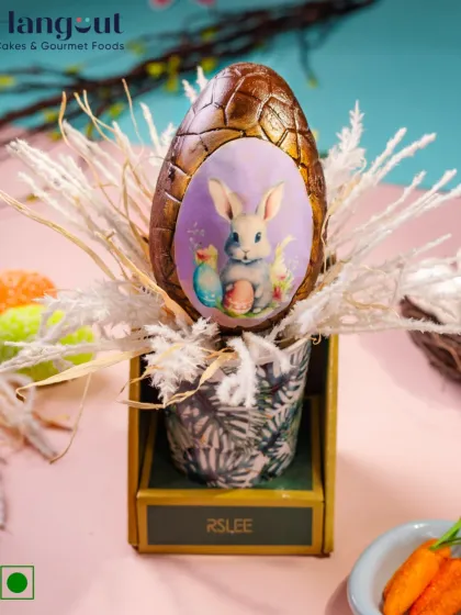 The Abundant Easter Egg Hamper is a perfect spring gift. It features a large, edible chocolate egg with a bunny design, presented in a floral sipper with fluffy dried flowers.