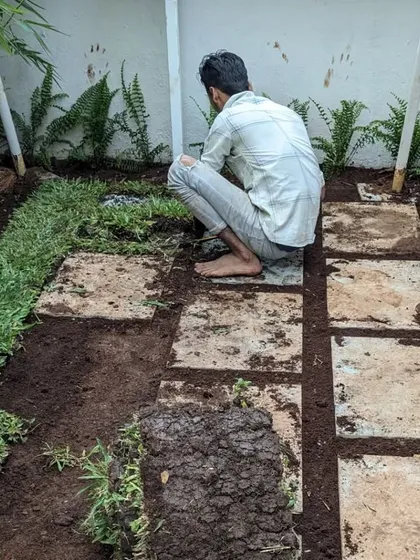 We fill the gaps between the stone slabs with soil and grass, integrating the hardscape feature naturally into the lawn.
