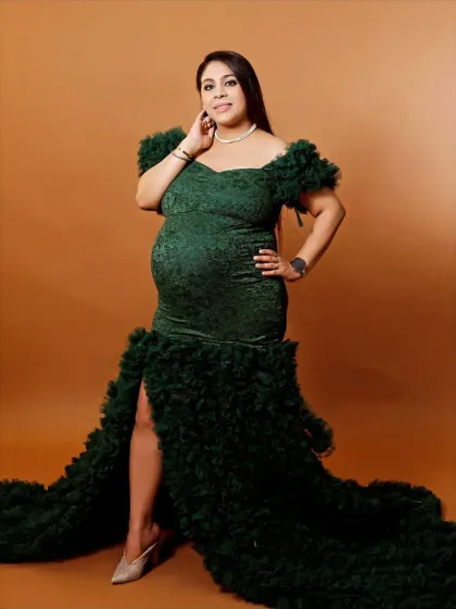 A confident and glamorous pose in a form-fitting green lace and ruffle gown, taken in our studio to highlight every detail.