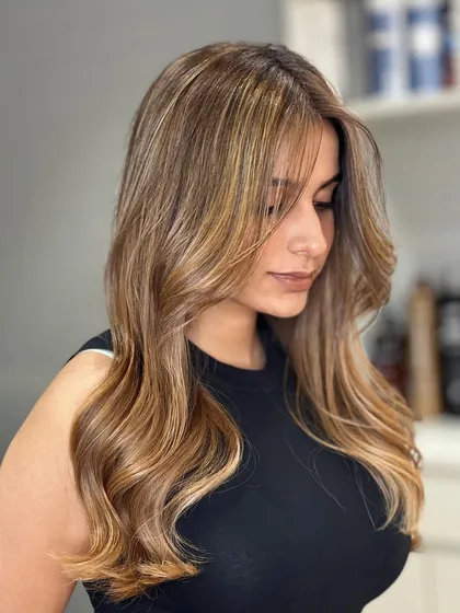 A happy client showing off her new Blonde Airtouch Balayage. The color perfectly frames her face.