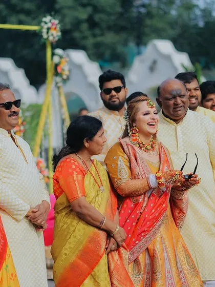 A candid moment of joy during the Haldi ceremony. The bride sharing a laugh with her family perfectly captures the happy and relaxed vibe of the event.