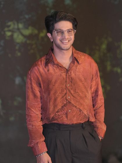 Dulquer Salmaan during the 'Lucky Bhaskar' promotions. The rich, rust-colored shirt paired with black trousers is a simple but effective combination that looks great on camera.