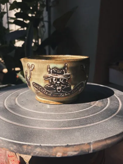 A little bit of Ghibli magic in this wheel-thrown matcha bowl. I've always been inspired by the whimsy of those films, and this piece, with its playful Totoro-like character, is a nod to that love. It’s made for fellow matcha lovers and dreamers.