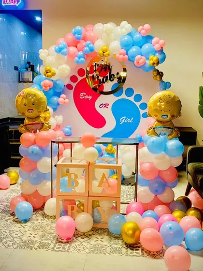 Is it a boy or a girl? I create fun and exciting gender reveal party decorations like this one. This setup includes a custom backdrop, "Boy or Girl" signage, and perfectly coordinated pink and blue balloons with cute foil baby balloons.