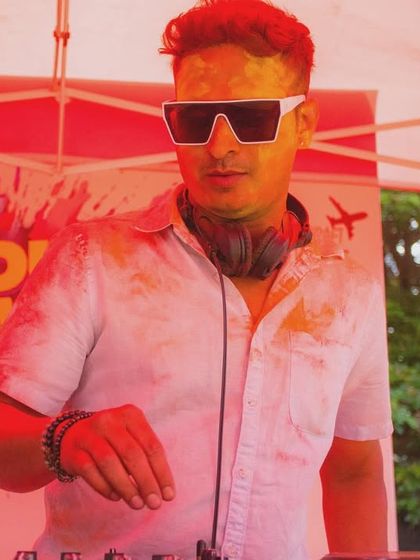 A DJ focused on the mix at our 'Colour Splash' Holi event, demonstrating the professional talent we book for our themed parties.