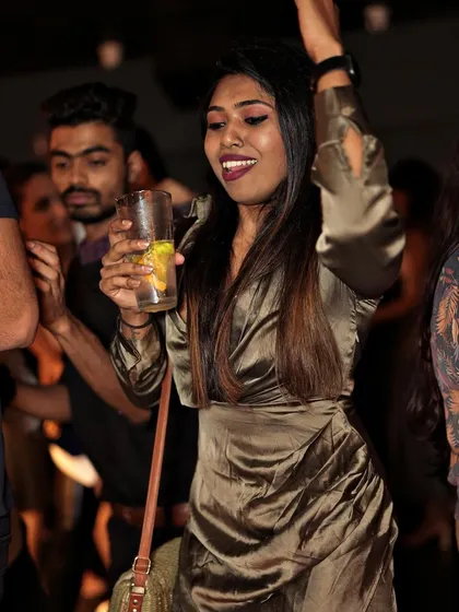 A guest enjoying her drink and dancing to the Afro and Latin house beats.