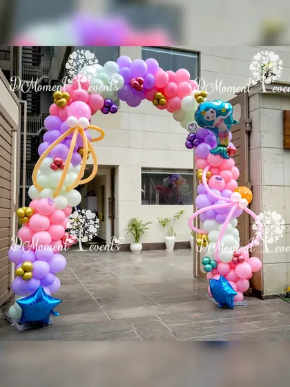 A whimsical balloon arch for a mermaid party, using a bright and fun color palette of pink, purple, and yellow with mermaid tail accents.